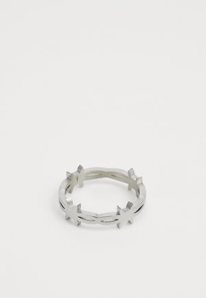 Anel de metal prateado com um design aberto apresentando acentos semelhantes a estrelas. Textura suave com um acabamento polido, forma circular.