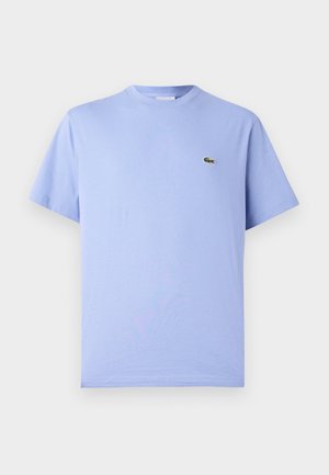 Lyseblå bomulds T-shirt med rund hals og korte ærmer. Har et lille broderet grønt alligatorlogo på brystet.