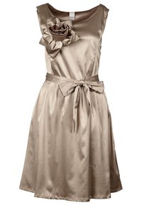 Satin beige klänning med en figursydd överdel, breda axlar och en stor blomma som accent. Har en midja med bälte och en A-linjär kjol.