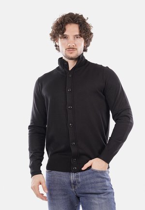 Cardigan in maglia nera con colletto alto e chiusura frontale con bottoni. Presenta polsini e orlo a coste. Texture liscia e forma aderente.