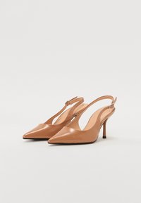 Sandales à talons en cuir tan avec des bouts pointus, des talons fins de 3 pouces, des côtés découpés et une sangle à boucle pour un maintien sécurisé.