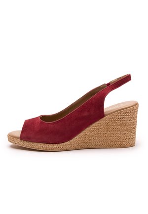 Czerwony sandał na klinie zamszowy, z odkrytym palcem i paskiem na pięcie. Posiada klinowy obcas z plecionej juty, dodający wysokości i faktury.