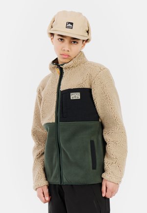Veste en polaire beige, verte et noire. Dotée d'une fermeture éclair, d'un col montant et de textures contrastées. Écusson logo sur la poitrine.
