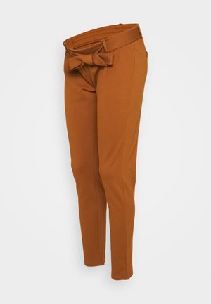 Rust-colored slim-fit pants with a high waist and fabric belt tied in a bow at the front.