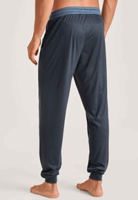 Heren navy joggers met een elastische tailleband en gatherde boorden, gemaakt van een soepel, lichtgewicht stof en een eenvoudig ontwerp.