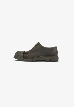 Brown leather shoe with a rubber toe cap and thick sole. Features stitching details and a lace-up design for secure fitting.