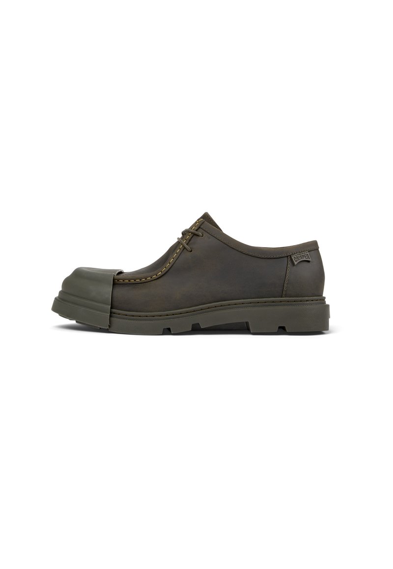 Scarpa in pelle marrone con punta in gomma e suola spessa. Presenta dettagli di cucitura e un design con lacci per una vestibilità sicura.