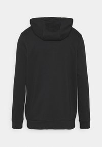 Sudadera negra con capucha, mangas largas y puños acanalados. Textura suave, diseño sencillo y sin logotipos ni patrones visibles.