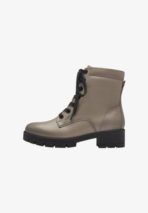 Women's ankle boots made of beige leather with a smooth finish, featuring black laces, a block heel, and a rugged sole design.