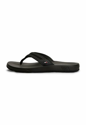 Einzelner schwarzer Flip-Flop mit Stoffriemen und kleinem rechteckigem Logo an der Seite, seitlich auf weißem Hintergrund dargestellt.