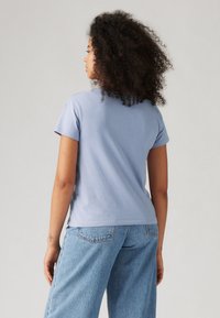 Lys blå bomulls t-skjorte med korte ermer, med et enkelt design. Kombinert med høyt liv lys blå denim jeans.