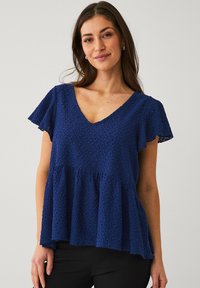 Marineblaues Oberteil mit V-Ausschnitt, kurzen, flatternden Ärmeln und einem gerafften Peplum-Design. Strukturierter Stoff mit einem floralen Muster.