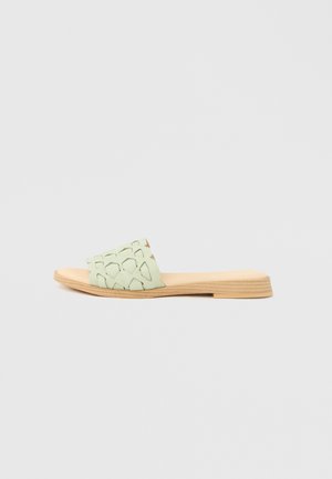 Sandale légère vert clair à enfiler, avec un design découpé sur la tige et une semelle au motif naturel effet bois. Profil plat et minimaliste.