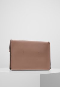 Brun läder crossover-väska med en slät yta, minimalistisk design och kedjearm. Har en framficka utan spänne.