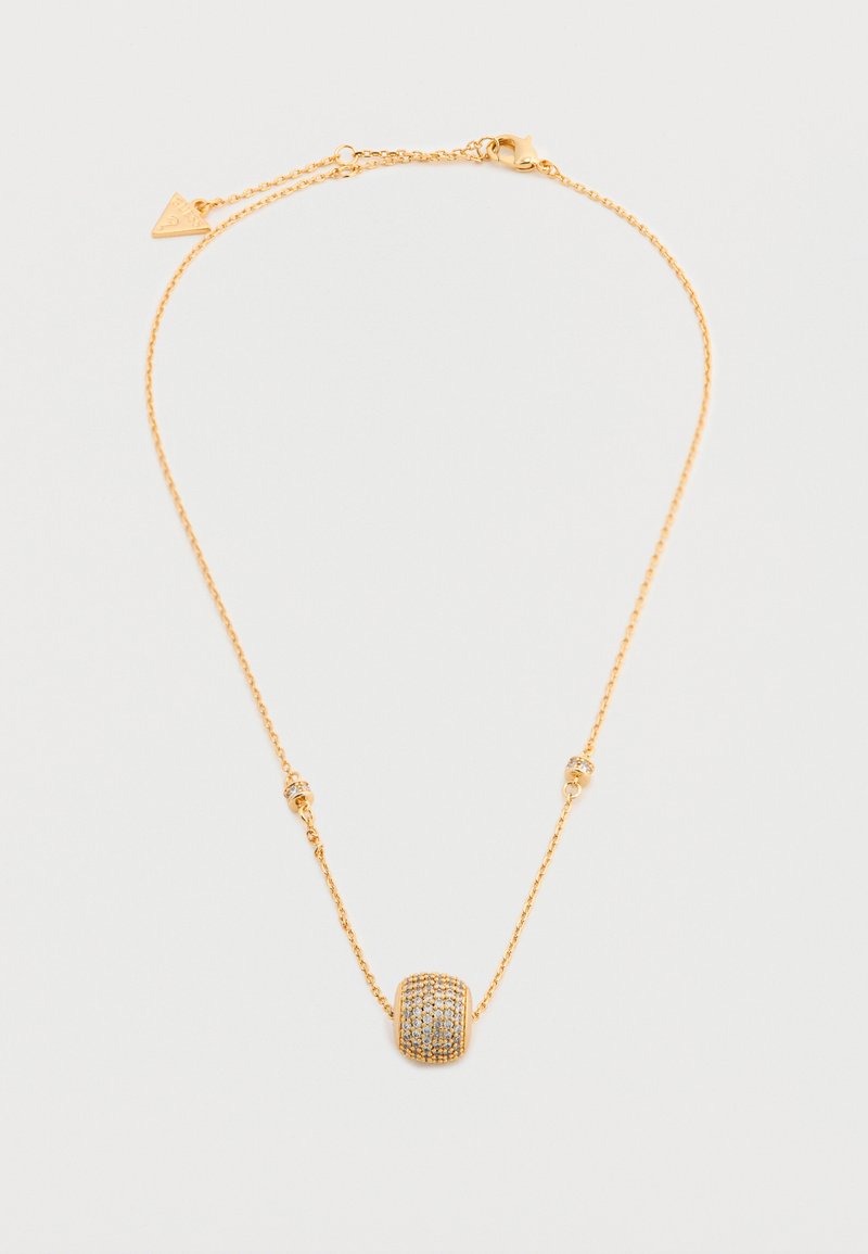 Λεπτή χρυσή αλυσίδα με κεντρικό μενταγιόν σε σχήμα βαρελιού, διακοσμημένο με μικρές λαμπερές πέτρες και ταιριαστά μικρότερα διακοσμητικά στοιχεία.