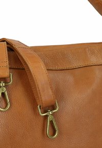 Bruine leren tas met een gestructureerde afwerking, voorzien van een stevige schouderband en hardware bevestigingen in goudtint.