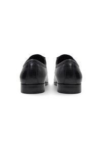Scarpe stringate in pelle nera con finitura liscia, punta arrotondata, tacco basso e design minimalista. Vista posteriore che mostra i dettagli delle cuciture.