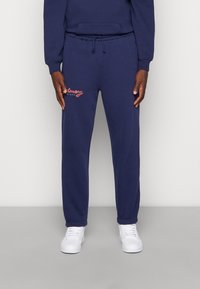 Navyblå sweatshirtbyxor i bomullsblandning, med elastisk midja och dragsko, avslut med ribbade anklar och vit logotypbrodering.