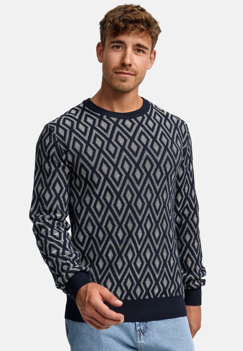Navy sweater with diamond pattern in cream, crew neckline, ribbed cuffs, and hem. Knit texture, medium weight fabric.