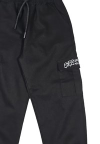 Pantaloni cargo neri con fascia elastica in vita dotata di coulisse, tasche laterali e una grafica bianca a contrasto sulla tasca laterale.