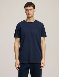 Granatowa koszulka z okrągłym dekoltem wykonana z bawełny, z krótkimi rękawami, luźnym krojem i subtelnym logo na piersi.