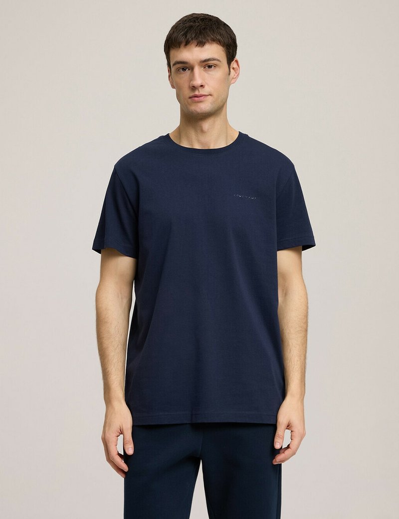 Granatowa koszulka z okrągłym dekoltem wykonana z bawełny, z krótkimi rękawami, luźnym krojem i subtelnym logo na piersi.