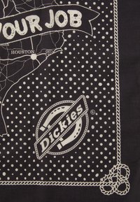 Sort bandana med hvide prikker og et kortdesign med teksten "DIN JOB," sammen med et logo for "Dickies" og dekorativt snore-detalje.
