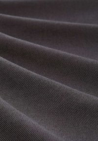 Gray textured fabric with a subtle herringbone pattern, displaying folds that emphasize its smooth and woven structure.