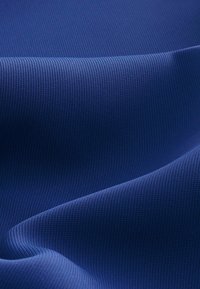 Gestructureerde blauwe stof met een ribbelpatroon, die een soepele en flexibele drapeert. De kleur is een diepe, rijke blauw.