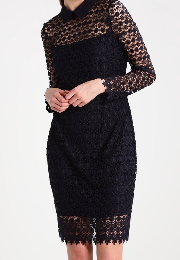 Navyblaues Spitzenkleid mit langen Ärmeln und kragen. Es hat florale Muster und einen gewellten Saum. Strukturiertes Material mit einer figurbetonten Passform.