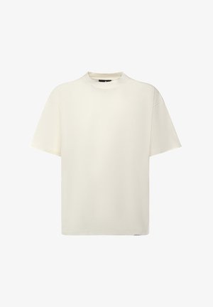 T-shirt a maniche corte con scollo rotondo in cotone avorio. Caratterizzata da una vestibilità comoda e una texture liscia. Design semplice senza motivi o dettagli visibili.