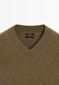 Maglione in lana verde oliva con colletto a V a costine, etichettato "Massimo Dutti", Made in China, materiale 100% lana.