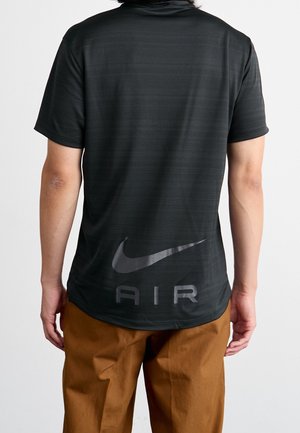 Schwarzes Nike-Shirt mit kurzen Ärmeln und dezenten horizontalen Streifen, mit reflektierendem Logo und dem Schriftzug "AIR" auf der Rückseite. Glattes, leichtes Material.