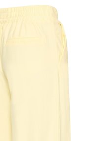Pantalon jaune pâle à taille élastique avec poches latérales et une poche passepoilée au dos, vu de profil et de dos.