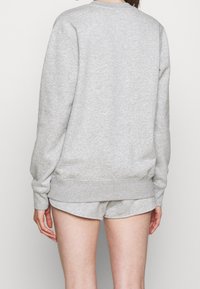 Felpa grigia con collo a giro, maniche lunghe e polsini a coste, realizzata in un tessuto morbido e testurizzato. Mostra la vista posteriore senza motivi notevoli.