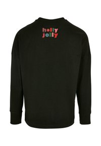 Melnas garām piedurknēm t-krekls ar daudzkrāsainu tekstu "holly jolly" dažādās rotaļīgās fontēs uz augšējām muguras daļām. M�īksts kokvilnas materiāls.