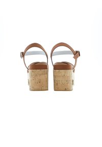 Hnědé kožené platformové sandály s nastavitelným obecním páskem a korkovou texturou na patě. Mají hladký, zaoblený design špičky.