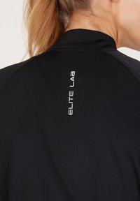Zwarte sporttop met een hoge kraag, voorzien van een reflecterende "ELITE LAB" logo langs de achterkant. Gladde stof met een fitted design.