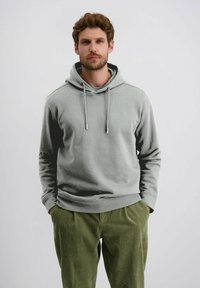 Grijze hooded sweatshirt met aangepaste koordjes, voorzien van een subtiel logo op de borst, gecombineerd met groene corduroy broek met textuur.