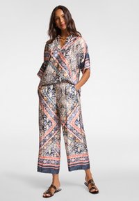 Bedrucktes Outfit mit einem lockeren, kurzärmeligen Oberteil und weitem Hosenbein. Verfügt über anspruchsvolle Muster in Pink, Blau und Beige auf einem weichen Stoff.