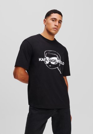 Camiseta de algodón negra con un gráfico blanco de una cara estilizada con gafas. Diseño de mangas cortas y un ajuste relajado.