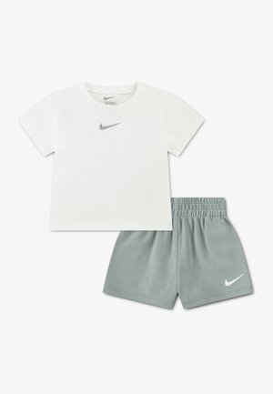 Wit Nike T-shirt met korte mouwen en grijze Swoosh-logo, gecombineerd met grijze shorts met elastische taille en witte Nike Swoosh.