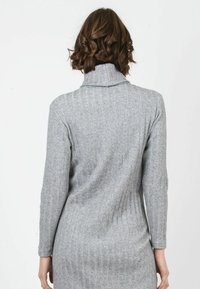 Graues, geripptes Strickkleid mit Stehkragen, langen Ärmeln und figurbetonter Silhouette. Das Material hat eine weiche Textur mit subtilen Variationen.