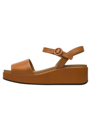 Tan læder platformsandal med åben tå, justerbar ankelrem, rund spænde og tyk sål med sort bund.