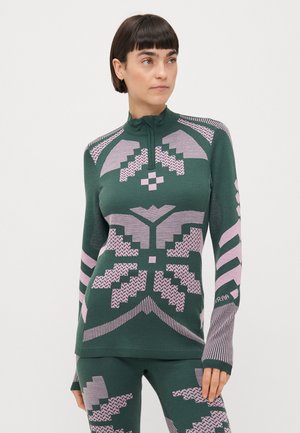 Grön långärmad topp med rosa geometriska mönster, hög krage och figursydd design. Har tumhål och en mjuk, texturerad yta.