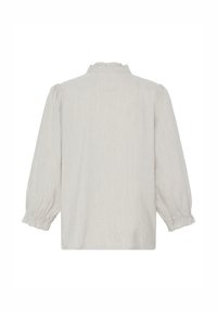Blouse beige clair à manches longues avec poignets froncés et petit col à volants, vue de dos sur fond blanc.