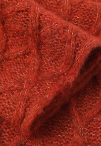 Tessuto a maglia rosso con un motivo a diamante testurizzato, realizzato in morbido filato con una leggera peluria e sottili variazioni di colore.