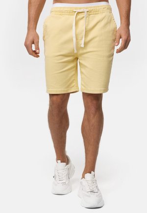 Lysegule bomuldsshorts med elastisk talje, snøre og sidelommer, med lige snit og længde over knæet.