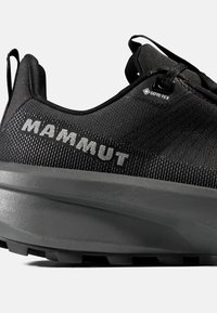 Svart utomhussko med en texturerad ovandel, GORE-TEX-märke och en tjock, hållbar gummisula med ett mönster för grepp.