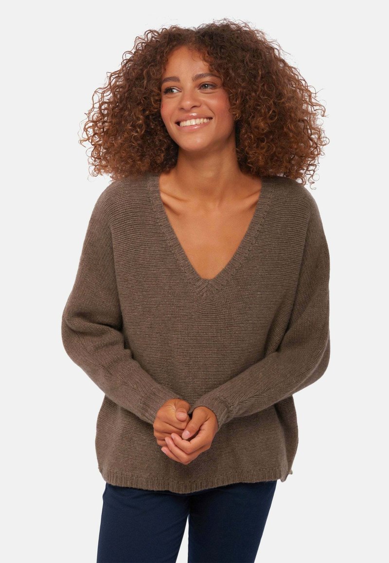 Pull en laine marron avec un décolleté en V profond, manches longues et poignets côtelés. Texture douce, coupe décontractée et détails de couture subtils.